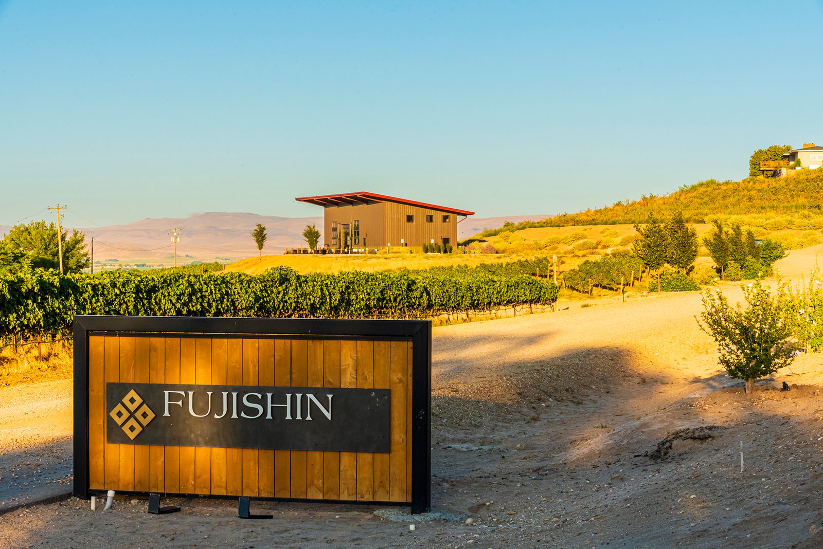 building sitting on a hill behind a wooden sign
